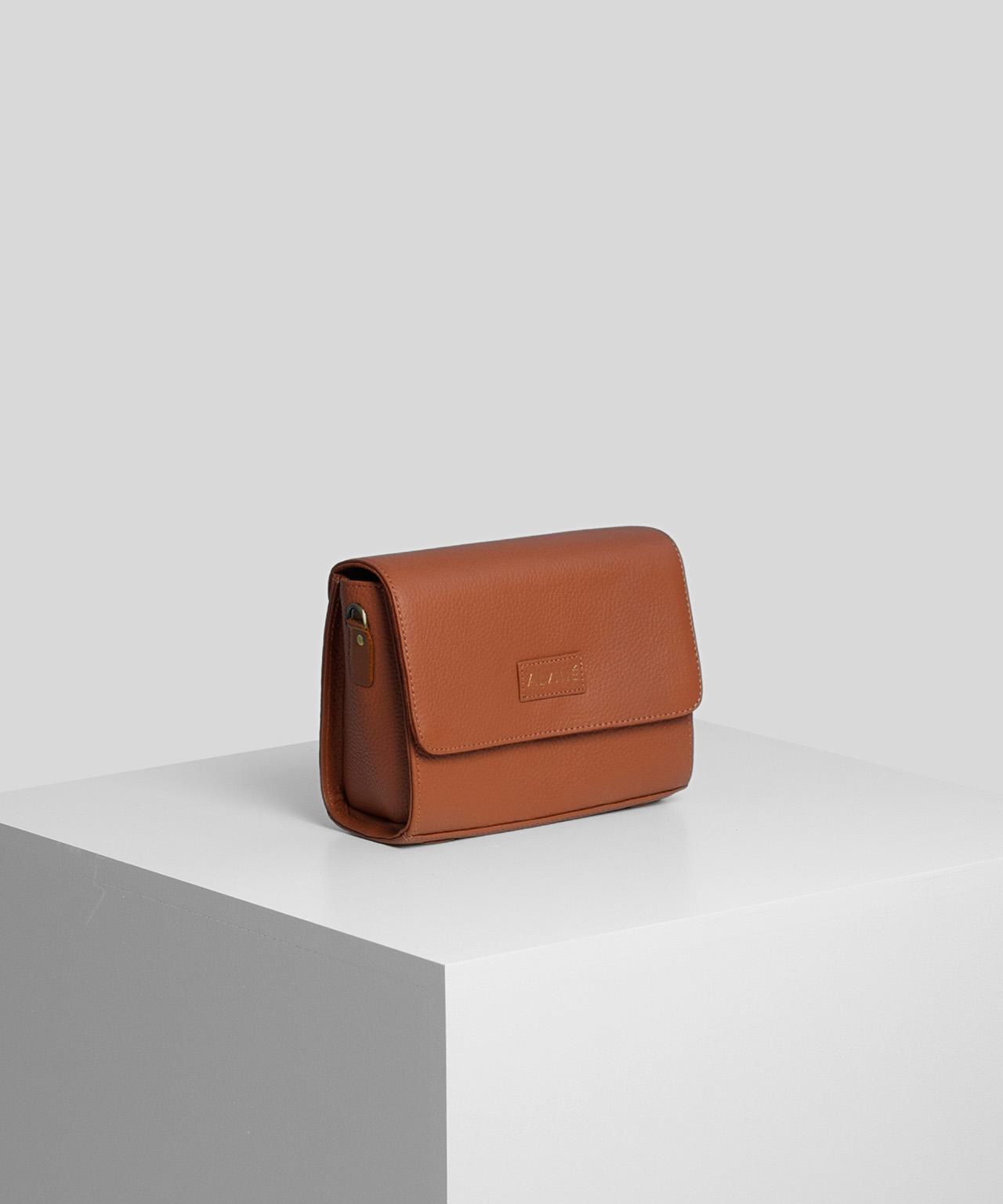 Pouch i cognac farve fra The Classic Collection på pedistal