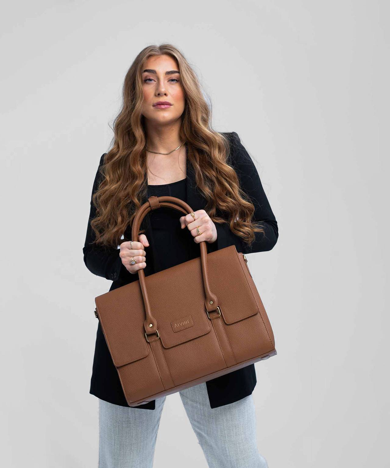 Model med The Classic Collection arbejdstaske i cognac læder i hånden